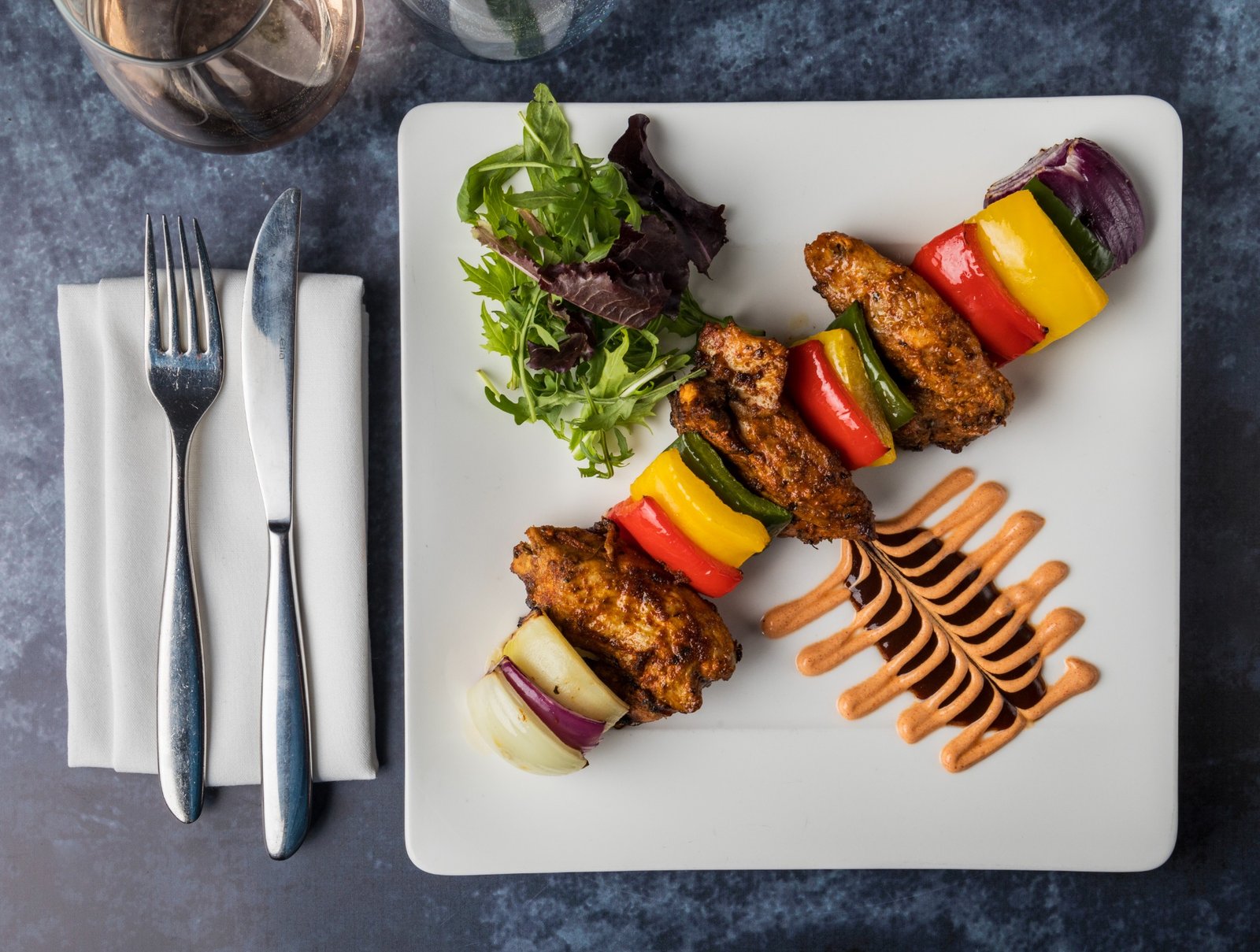 Colourful tandoori skewers plated at La Indika